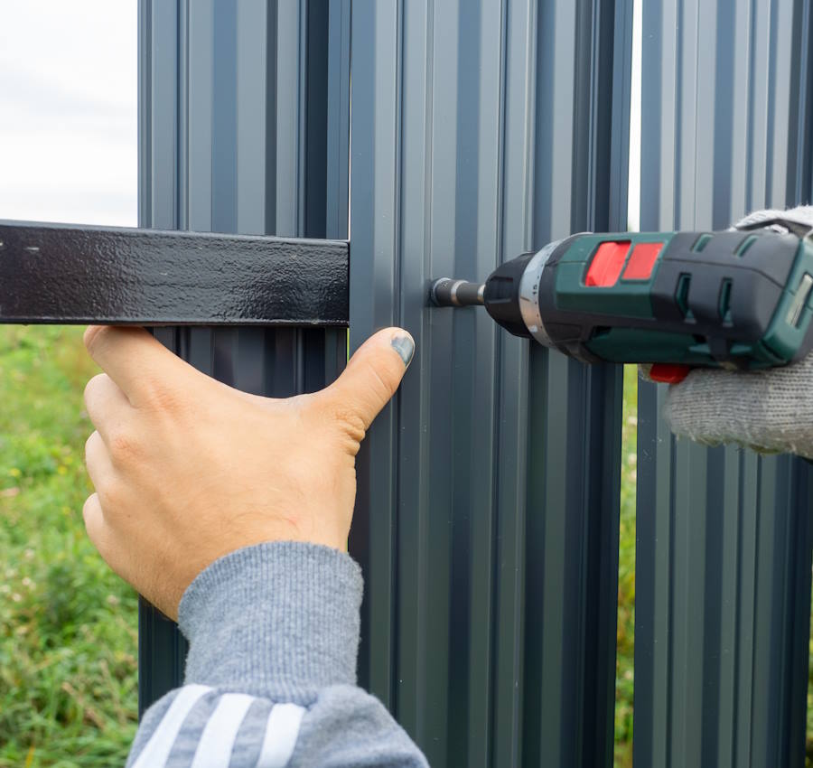 man-using-screwdriver-twists-metal-picket-fence-fence-worker-professional-construction-fencing-security-own-territory